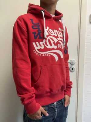 Superdry hoodie - Det röd hoodie från Superdry i storlek S. Mycket bra skick. Modellen är 173cm, 64kg. Pris kan diskuteras!!