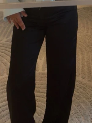 Svarta satin byxor - Jag säljer ett par svarta satin byxor som är köpta på pull and bear. De är i bra skick, jag har kortat ner dem lite men det är absolut inget man märker, jag är 163 cm lång och jag skulle säga att de passar en person upp till 170 cm. De är i storlek S. Finns någon liten brännskada på låret men absolut inget man lägger märke till. 