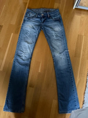 Blå bootcut jeans med slitningar - Snygga blå bootcut jeans.