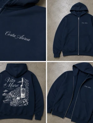 Mörkblå hoodie med dragkedja och tryck - Mörkblå hoodie med dragkedja och huva. Framsidan har broderad text 'Costa Aurea' och baksidan har ett stort vitt tryck med motiv av en vinflaska, frukt och texten 'Vita di Mare'. Två fickor fram och ribbade muddar. Perfekt för en chill och stilren look.