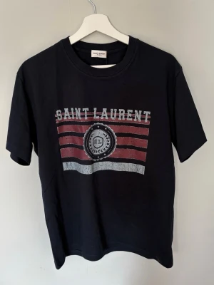 Saint Lauren t shirt  - Säljer en helt ny oanvänd Saint Lauren t shirt. Storlek M men passar mer som S. Mörkblå/Svart färg