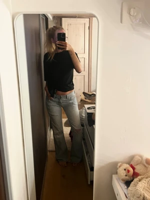 Ljusblå bootcut jeans med slitningar - Suuuuper snygga Bootcut jeans som tyvärr inte kommer till användning längre. Dom är mid/low waist och är långa i modellen, jag är 171. Dom är i toppen skick.