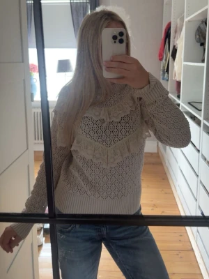 Beige stickad tröja med spetsdetaljer - Supersöt beige stickad tröja med spetsvolanger över bröstet och armarna. Varm och skön till kallare tider💕(barnstorlek men sitter som en S/M)