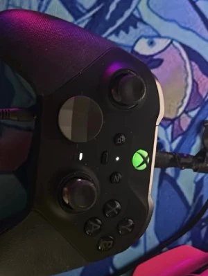Svart Xbox Elite handkontroll - Säljer en svart Xbox Elite handkontroll med gummerade grepp, justerbara spakar och extra knappar. Kontrollern har en modern design med tydliga knappar och en ikonisk Xbox-logga i mitten. Perfekt för gaming på hög nivå.