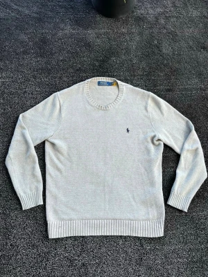 Ralph Lauren stickad  - Säljer en ljusgrå stickad tröja från Polo Ralph Lauren som är i väldigt bra skick, hör av er vid frågor eller funderingar