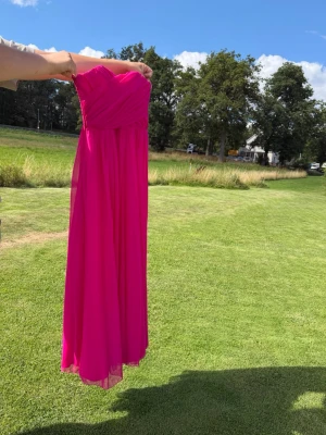 Balklänning i chiffong - Balklänning i chiffong  Kjol med undertyg.  Dragkedja i sidan upptill.  Inbyggda kupor. Uppsydd till bal och använd en gång.   Mått:  36cm upptill 24cm från toppen till midja  33,5 i midja 127cm lång, något längre bak 