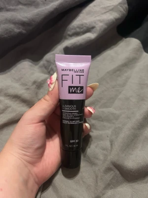 Maybelline Fit Me Luminous Primer - Maybelline Fit Me Luminous + Smooth Primer i tub med lila och svart design. Innehåller SPF 20 och är framtagen för normal till torr hud. Ger en återfuktande och jämn bas med naturligt glow. Tuben rymmer 30 ml.