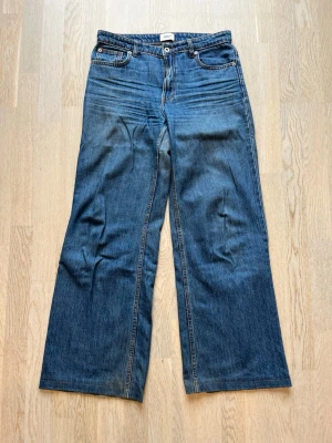 Blåa vida jeans med hög midja - Säljer ett par blåa jeans med hög midja och vida ben. Klassisk femficksmodell med knapp och dragkedja framtill. Jeansen har en snygg tvättad look och är gjorda i denim. Perfekta för en avslappnad och trendig stil. Tveka inte på att skriva en fråga eller be om fler bilder.🌸🌸