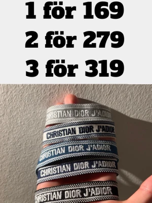 Christian Dior J'Adior armband - Snygga armband från Christian Dior med texten 'J'Adior'. Finns i olika färger som grå, blå, svart och vit. Armbanden är vävda i tyg och har tofsar i ändarna för en trendig look. Perfekt accessoar för att lyfta din outfit.