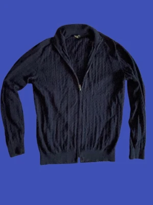 Massimo Dutti kabelstickad zip - Mörkblå kabelstickad tröja från Massimo Dutti i storlek L. Tröjan har dragkedja framtill och ståkrage. Tröjan har ett diskret mönster och ribbade muddar vid ärmslut. Fråga gärna om du undrar något! Priset är inte hackat i sten.