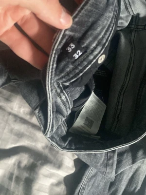 Gråa Regular Clark jeans Jack & Jones - Säljer ett par gråa jeans från Jack & Jones i modellen Regular Clark. Klassisk femficksdesign, raka ben och snygga kontrastsömmar. Perfekta för dig som gillar en avslappnad men ändå stilren look.