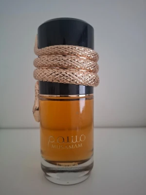 Lattafa Musamam edp - Toppnoterna är Saffran, Mandarin och Lavendel; hjärtnoterna är Ambra trä, Cederträ och Pelargon; basnoterna är Akigalawood, Rökelse och Labdanum