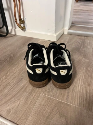 Puma Suede Classic  Svart/Brun sula - Säljer ett par klassiska svarta Puma Suede med snygg rågummisula. Skorna är använda men i helt ok skick och har mycket kvar att ge. Perfekta, sköna vardagssneakers! Ny pris ca 1000