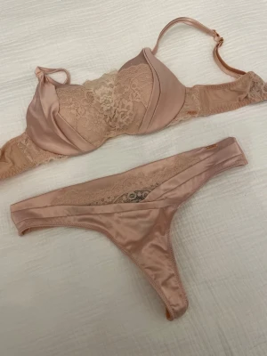 Beige set från Noir - Snygg set från Noir by Hunkemöller med spetsdetaljer och satinliknande material. 