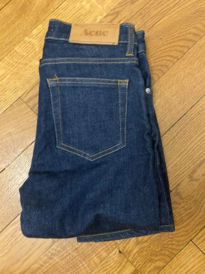 Acne jeans - Säljer ett par snygga mörkblå acne studio jeans i storlek W25 L32 ganska skinny. Har en skön orange sömm och är perfekta till hösten jag är 167 men skullle säga att de passar bra till någon 160 till 165. Pris kan diskuteras.