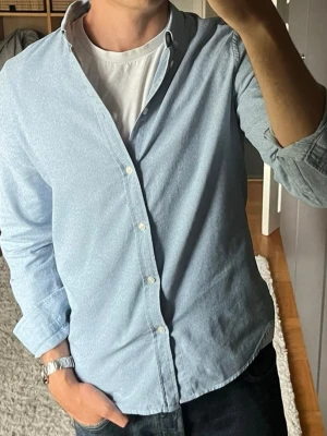 Samsøe Samsøe Liam skjorta i ljusblå - stl M - Samsøe Samsøe Liam-skjorta i ljusblå, storlek M i 100% bomull med button down-krage och lite struktur i väven.  Använd men i mycket fint skick, inga hål eller fläckar.  Personen på bilden är 189cm, väger 78kg.  Rök- och djurfritt hem. Skriv gärna om du vill ha fler bilder eller undrar något!