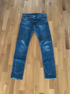 Blå jeans från &Denim - Säljer ett par klassiska blå jeans från &Denim i storlek 30/32, jeansen är knappt använda och är i ett mycket bra skick. Passformen är slim och passar perfekt för en som lever efter en stilren look
