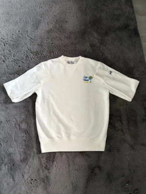 Vit sweatshirt med broderi - Vit sweatshirt med rund hals och broderad text samt palm på bröstet. Tröjan har ribbade muddar vid ärmslut och nederkant samt en avslappnad passform. Perfekt för en chill och stilren look.