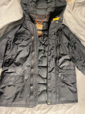 Svart parkasjacka med huva - Very good looking, high quality and warm. Ask anything. Pockets everywere so you dont need bag.