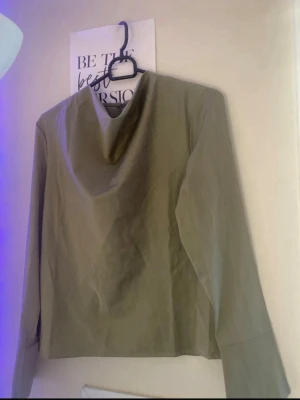 Louise Blouse – Ny med tagg - Säljer en helt ny, olivgrön Louise Blouse med tagg kvar. Blusen har en elegant draperad halsringning och långa ärmar. Perfekt för både vardag och fest! Nypris 349 kr. Kan skickas eller mötas upp. Vid frågor om storlek eller passform, skriv gärna!