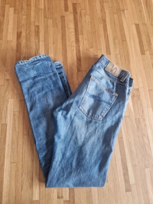 Nudie Jeans - Säljer dem här blåa nudie jeansen | den är i storlek w29 l32 och modell steady eddie | jeansen är I okej skick med ett hål i högra knät och få hål i fickan | skriv gärna om du har några funderingar eller frågor 