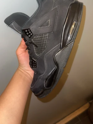 Svarta höga sneakers med meshdetaljer - Snygga helsvarta sneakers med högt skaft och meshdetaljer på sidorna. Skorna har en robust sula med synlig luftbubbla och svarta skosnören. Materialet är en mix av mocka och textil, vilket ger en cool och modern look.