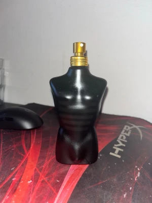 125ml flaska med 60% kvar - Cool parfymflaska i form av en manlig byst, helsvart med matta och blanka detaljer samt guldfärgad spraytopp. Flaskan har en unik och stilren design som sticker ut på hyllan. Perfekt för dig som gillar snygga och annorlunda parfymflaskor.