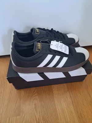 Adidas VL court 2.0 - HELT NYA! Skorna har aldrig använts och prislappen tillkommer på ena skon (se bild). Storlek 44. Hör av er vid funderingar!