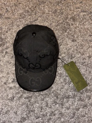 Guccii keps - Jumbo svart med tags 