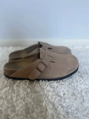 Birkenstock Boston  - Tja! Säljer nu ett par schyssta Birkenstock tofflor i den den populära modellen ”Boston”. Det är använda några gånger men är fortfarande i mycket fint skick. Mockan är i fint skick. Hör av dig om du har några frågor☺️