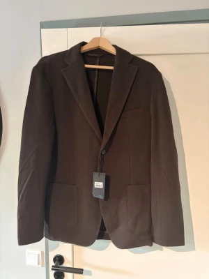 Brun stickad kavaj John Henric - Hej! Säljer nu en helt ny brun John Henric stickad kavaj i storlek M. 