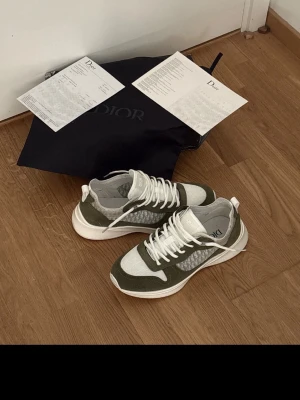 Gröna och vita sneakers  - Stilrena sneakers i grönt och vitt med meshpaneler och mockadetaljer. Skorna har vita snören, tjock vit sula och en modern, sportig look. Perfekta för dig som gillar trendiga och bekväma sneakers med snygga detaljer.