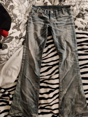 2000s bootcut jeans - Bootcut jeans i ljusblå denim med slitningar och lätt tvättad look.Den är liten i storleken. Är min mammas från 2000 talet och skulle säga att den är i strl xs