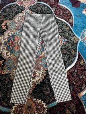 Rutiga leggings med hög midja - Snygga leggings med svartvitt rutmönster och hög midja. De har en bred resår i midjan för extra komfort och är tillverkade i ett stretchigt material som sitter tajt längs benen. Perfekta för dig som gillar en trendig och bekväm stil.