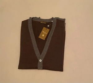 Brun cardigan /Stenströms - Snygg brun cardigan från Stenströms med grå ribbstickade muddar och knappslå. Tröjan har v-ringning, långa ärmar och är tillverkad i ett tunt, mjukt material som känns lyxigt. Perfekt för lager på lager och stilrena outfits.