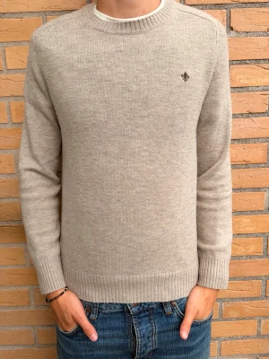 Beige stickad tröja (Morris) - Tjena! säljer nu en beige stickad tröja med rund hals och diskret broderad logga på bröstet. Tröjan har långa ärmar och ribbade muddar vid ärmslut och nederkant. Tröjan är köpt på NK i Göteborg, tveka inte att höra av dig vid frågor! Mvh Leo.