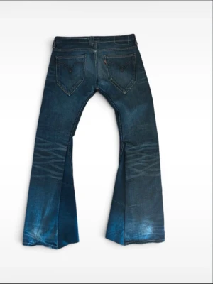 Levis bootcut  - Levis-jeans som har anpassats till en mer bootcut-passform. Riktigt coola detaljer som en myntficka med dragkedja, spetsiga bakfickor och mer. Ursprungligen storlek W33/L32 men passar nu mer som W32/L34
