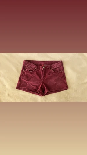 Vinröda jeansshorts med fickor - Snygga vinröda jeansshorts med klassisk femficksdesign, bälteshällor och knappgylf. Shortsen har råa detaljer och är perfekta för varma dagar. Passar dig som vill ha en trendig och avslappnad stil.