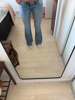 Ljusblå bootcut jeans - Säljer ett par ljusblå bootcut jeans från Gina Tricot. Jeansen har det klassiska femficksdesign och är lågmidjade. Jeansen har en lätt utsvängd passform nertill och är tillverkade i denim med en snygg tvätt. Jag är 176 cm och de passar parfekt.💕💕