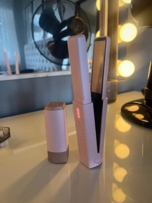 Plattång - Säljer en liten, portabel, bärbar plattång i ljusrosa och beige färg. Plattången har slät yta och LED-indikator och har ett elegant lock och metallisk topp. Perfekt för styling och snabba touch-ups, Perfekt till skolstarten att ha i skåpet. Använd max 1 gång från Roza Essentials.