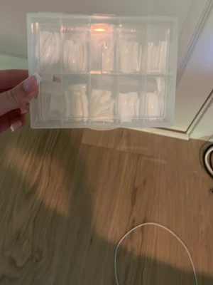 Vita press-on naglar i olika storlekar - Säljer ett set med vita press-on naglar i olika storlekar, levereras i en praktisk plastlåda. De är tippar. Perfekt för dig som vill fixa snygga naglar snabbt och enkelt hemma.