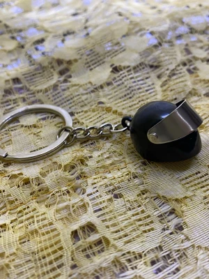 Nyckelring med hjälmberlock - Unik nyckelring med en liten hjälmberlock i metall. Hjälmen har en blank visirdetalj och finns i både svart och silverfärg. Perfekt accessoar för dig som gillar motorcyklar eller vill ha något coolt till dina nycklar. 48kr/st 