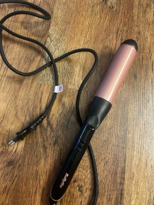 Locktång från BaByliss i roséguld - Säljer en snygg locktång från BaByliss i roséguld och svart. Den har en sladd med EU-kontakt, två knappar för temperaturinställning och ett greppvänligt handtag. Perfekt för att fixa lockar snabbt och enkelt. Använd 2 gånger så den är som ny