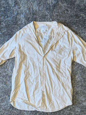Vit skjorta från 157 i bomull - Klassisk vit skjorta från 157 i storlek M. Skjortan har lång ärm, knappar framtill och är tillverkad i mjuk bomull. Enkel och stilren design som passar till många olika looks.