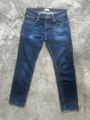  Snygga Hilfiger Denim Jeans i mörkblå tvätt (W32/L32) - Snygga mörkblå jeans från Hilfiger Denim med fin tvätt och klassiska detaljer. I mycket gott skick! 