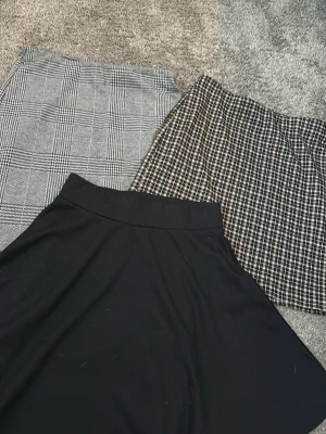 3 kjolar - Köparen står för frakt. Säljer tre fina kjolar från H&M i olika modeller. Två är rutiga i grå/svart och beige/svart, och en är klassiskt svart med fint fall. Perfekta att matcha med både toppar, blusar och tröjor! 🖤🤍✨ ✨ Märke: H&M ✨ Färg: Grå/svart, beige/svart och svart ✨ Storlek: Xs ✨ Antal: 3 kjolar ✨ Skick: Fint använt skick. Hör gärna av dig om du har frågor eller vill ha fler bilder! 💕