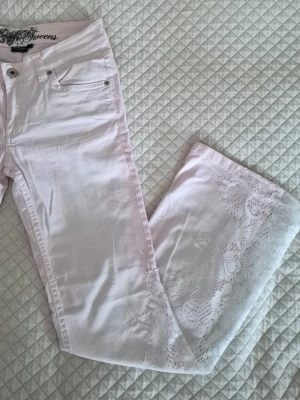 Jeans med vit spets - Säljer dessa low waist bootcut jeans med spets🤍 Ljusrosa i färgen med vit spets vid bensluten. Noggrant handsytt av mig!  Passar någon som bär xs och är ca 160 cm lång  Mått Innerbenslängd: 73 cm Midja (tvärs över): 35 cm 