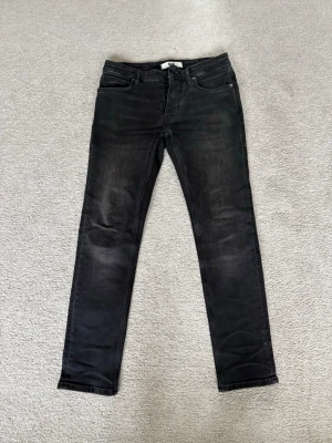 NEUW jeans LOU svarta 28,30 - Säljer ett par svarta slim fit NEUW jeans modell LOU storlek 28, 30. Fint skick nästan nya använda endast tre gånger. Kommer även med en cool nyckelring fäst bredvid höger framficka. 