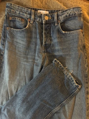 Raka jeans Zara - Mörkare raka blå jeans från Zara, lite slitna nertill i storlek 34. 