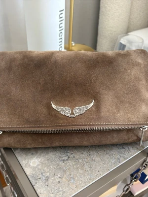 Brun mocka axelväska med kedja - Väska från Zadig & Voltaire som är lite sliten på kedjan och mockan men inget som syns jätte mycket. Det långa bandet är oanvänt